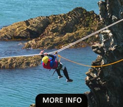 Man dangling on a rope while Sea Level Traversing on Anglesey
